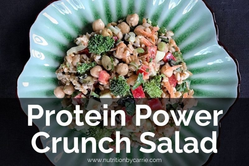 Photo of a veggie, chickpea and whole grain salad (veggies are broccoli and red pepper) photographed from overhead, on an old-fashioned sea green plate.