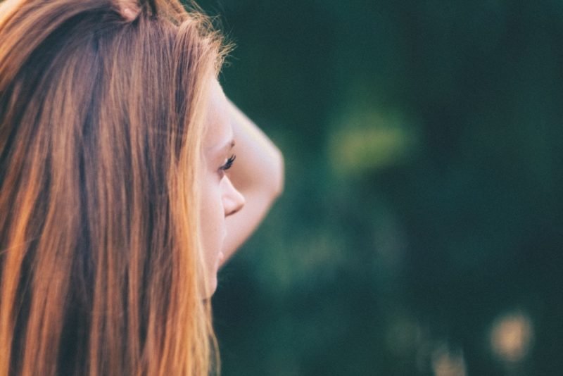 Part of honoring hunger means accepting that your food needs may vary from day to day. Profile photo of a young woman with long brown hair, against a blurred green background.